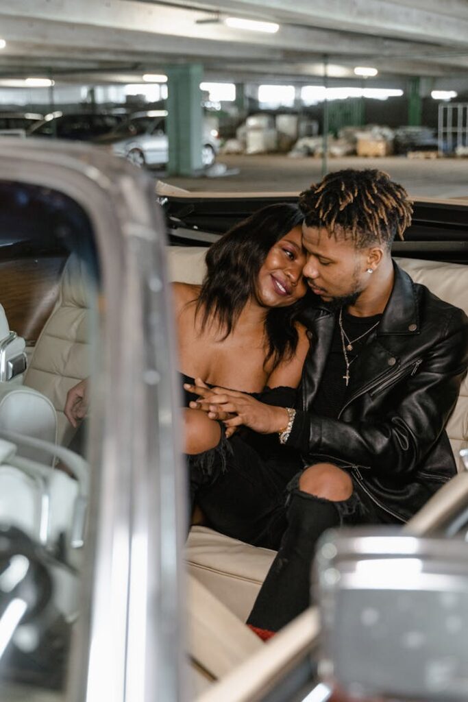 Romantic couple enjoying a close moment in a parked luxury car, depicting love and connection.